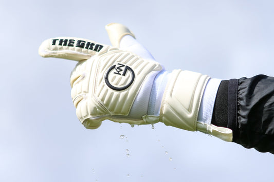 Goalkeeper washing their GKN gloves under running water