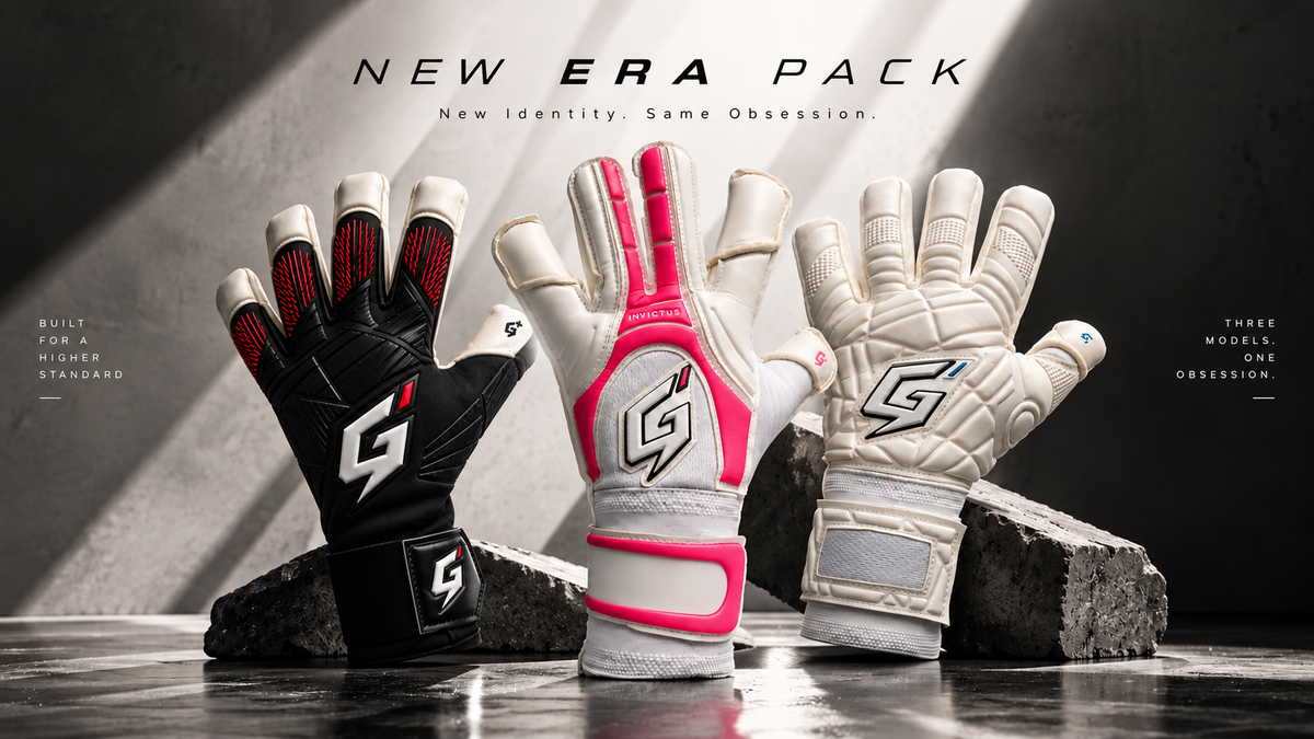 Three goalkeeper gloves displayed upright on dark blocks in a dramatic studio setup. The left glove is black with red and white accents, the center glove is white with bright pink panels and a large white logo, and the right glove is white with gray paneling and a white logo.